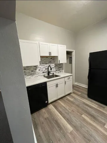 a view of kitchen with sink and refrigerator