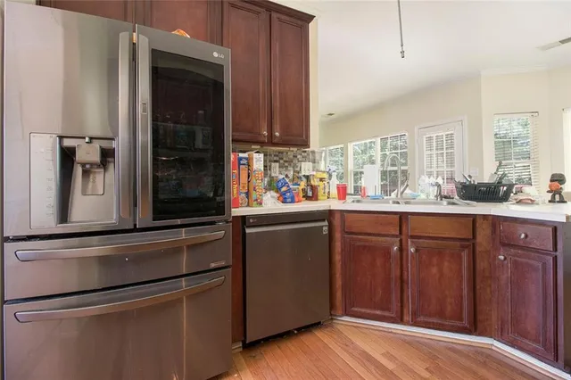 a kitchen with stainless steel appliances granite countertop a refrigerator and a sink