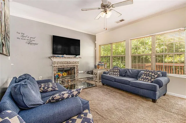 a living room with furniture a flat screen tv and a large window