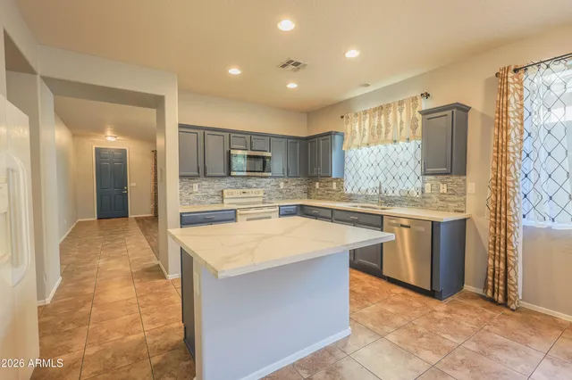 a large kitchen with kitchen island a sink stainless steel appliances and cabinets