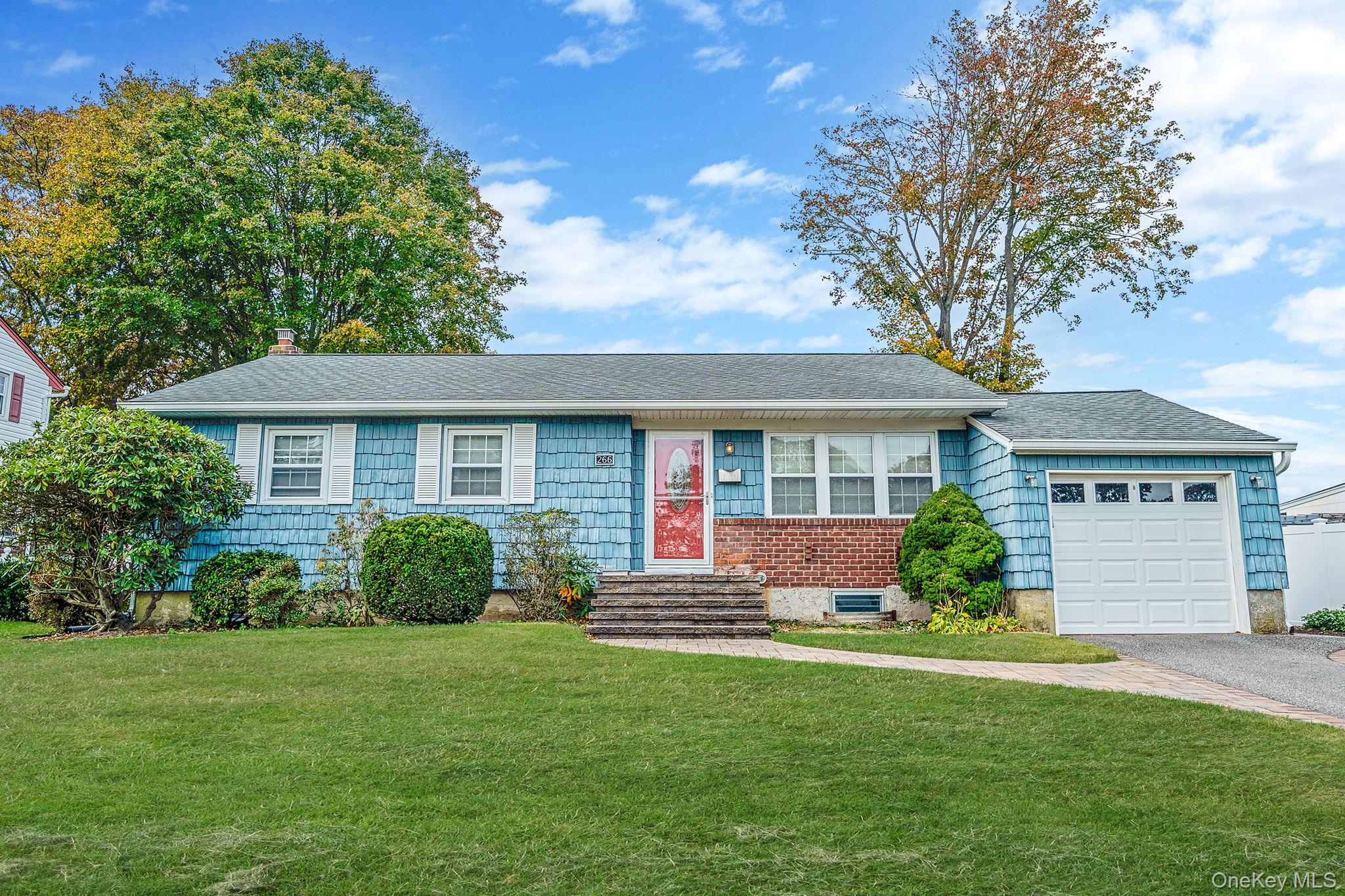 266 Tree Road Centereach, NY 11720 - Photo 1 of 1 Ranch-style home featuring a front lawn, a shingled roof, asphalt driveway, a chimney, and a garage