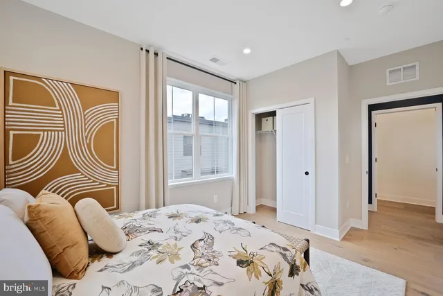 a bedroom with a bed and a large window