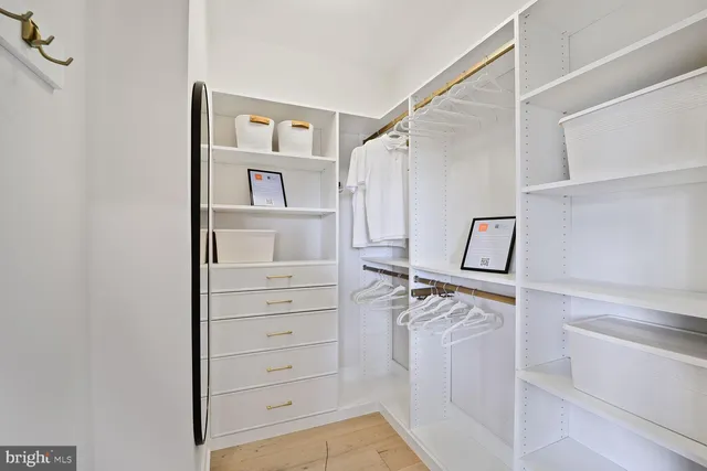 a view of a hallway with wooden floor and a living room