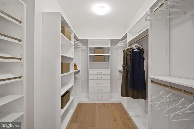 a bedroom with a bed cabinets and a dresser