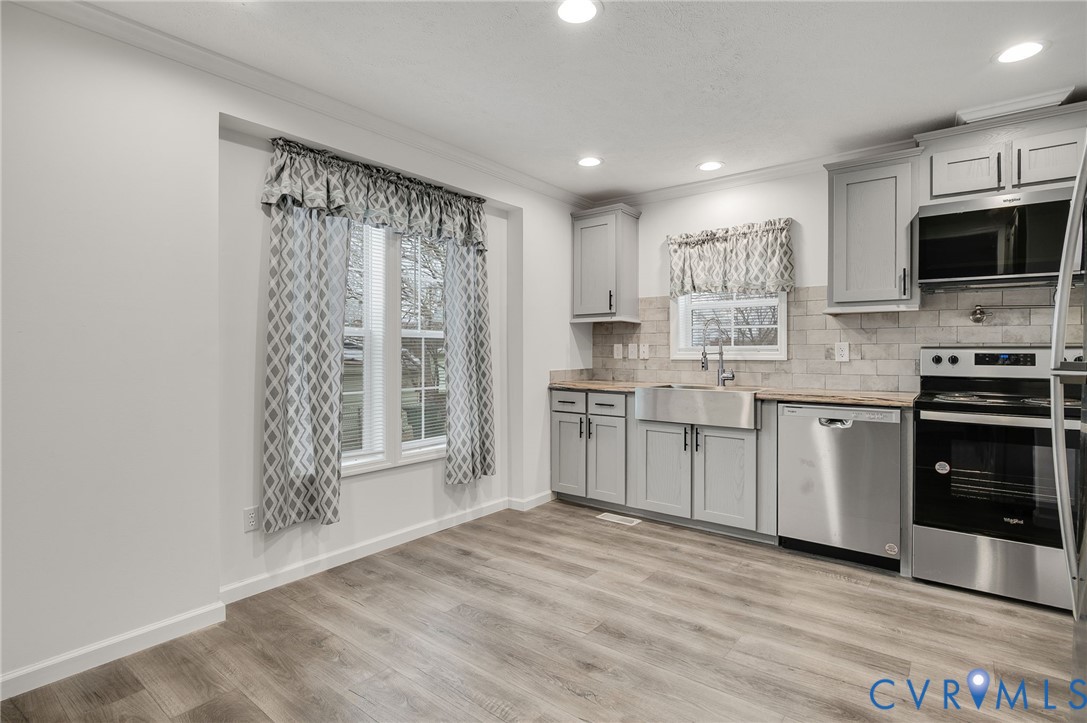 751 South Jones Street Petersburg, VA 23803 - Photo 6 of 13 a kitchen with stainless steel appliances granite countertop a stove top oven a sink and a granite counter tops with white cabinets