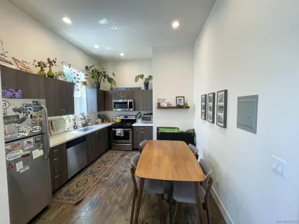 a kitchen with stainless steel appliances kitchen island granite countertop a sink dishwasher stove and refrigerator