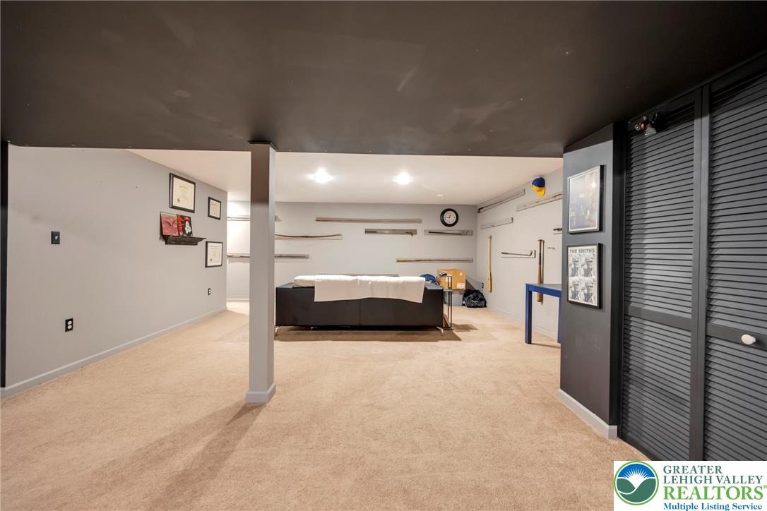 204 Bushkill Ridge Road Wind Gap, PA 18091 - Photo 39 of 48 A well-lit, spacious finished basement offers versatile living space with plush carpeting throughout.