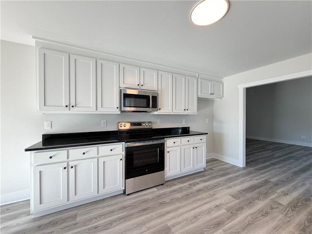 106 Charlie Way Winder, GA 30680 - Photo 4 of 23 a kitchen with granite countertop a sink cabinets and stainless steel appliances