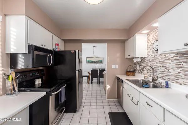 a kitchen with granite countertop a sink appliances and cabinets
