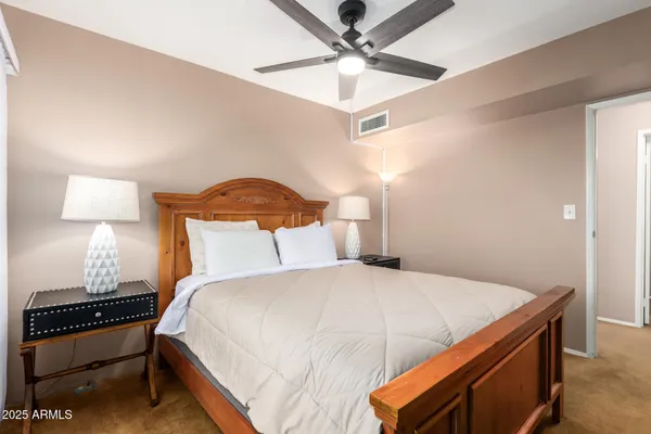 a bedroom with a bed and a lamp on a dresser