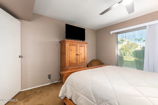 a bedroom with a bed tv and a window