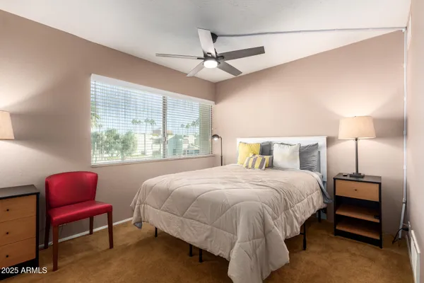 a bedroom with a bed a chandelier and a window