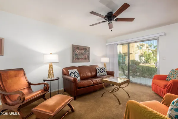 a living room with furniture a large window and a chandelier