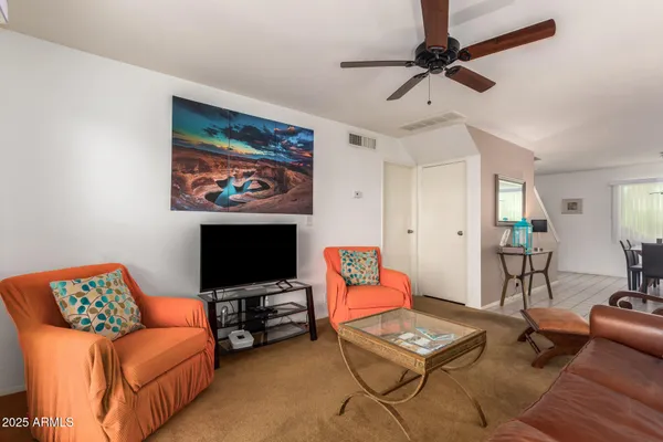 a living room with furniture a rug and a flat screen tv