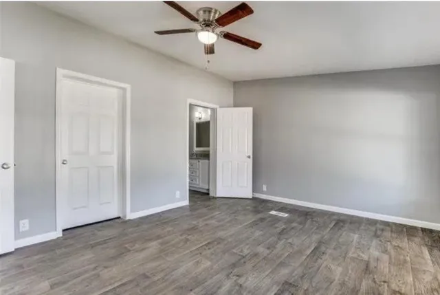 a view of a big room with wooden floor and a ceiling fan