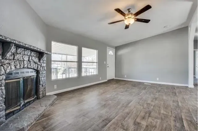 a view of an empty room with a fireplace and a window