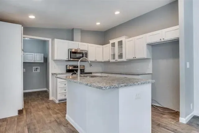 a kitchen with kitchen island granite countertop a sink and chandelier
