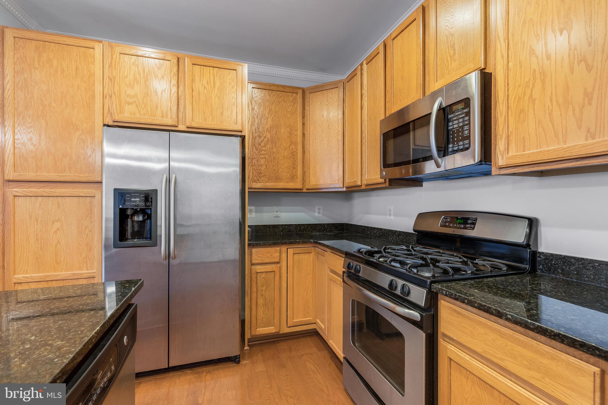 9409 Stonewall Road Manassas, VA 20110 - Photo 7 of 26 a kitchen with stainless steel appliances granite countertop a refrigerator a stove and a sink