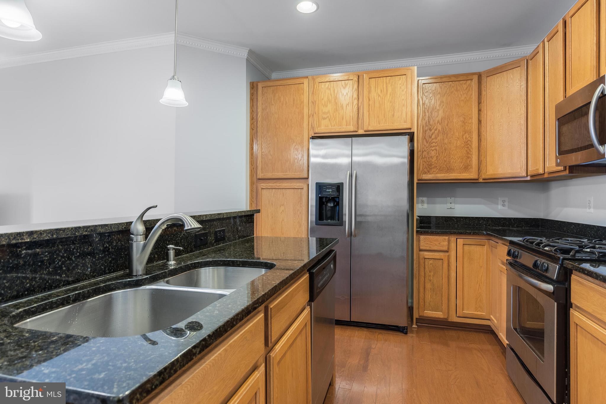 9409 Stonewall Road Manassas, VA 20110 - Photo 8 of 26 a kitchen with granite countertop a refrigerator and a sink