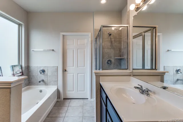 a bathroom with a tub sink and mirror