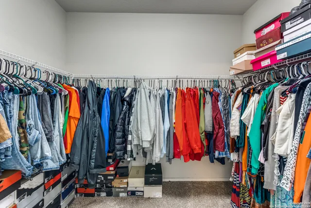 a view of walk in closet with clothes