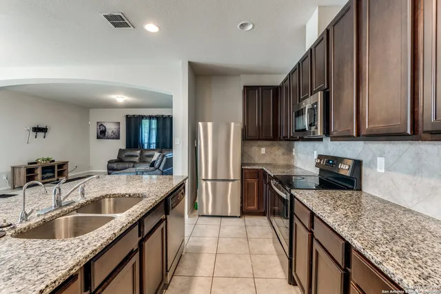 a kitchen with stainless steel appliances granite countertop a sink stove and refrigerator