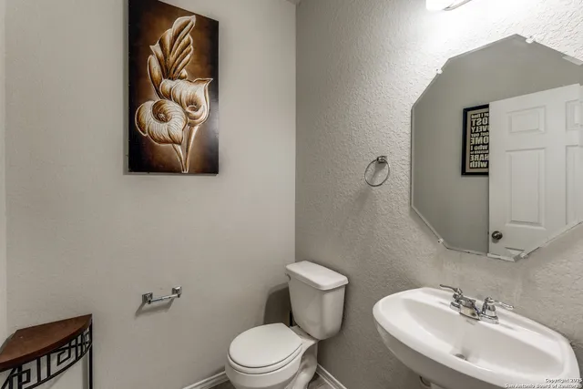 a bathroom with a toilet sink and mirror
