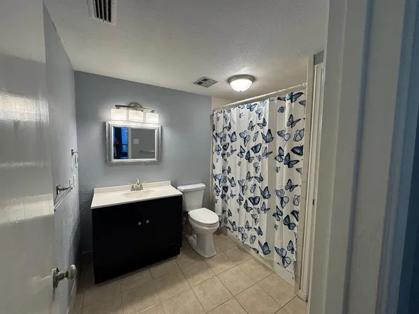 a bathroom with a double vanity sink toilet and mirror