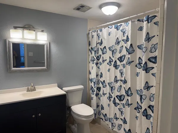 a bathroom with a sink and mirror with toilet