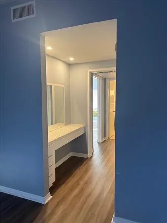 an empty room with wooden floor and window