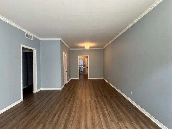 a view of empty room with wooden floor
