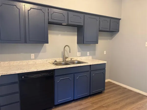 a kitchen with a sink cabinets and wooden floor