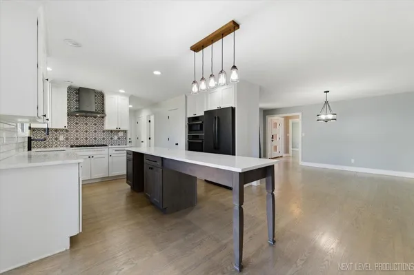 a large kitchen with kitchen island a sink stainless steel appliances and cabinets