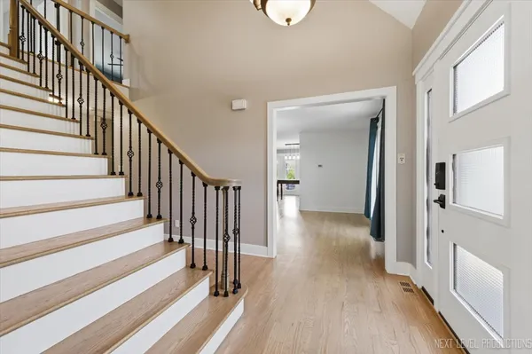 a view of a hallway with wooden floor and staircase