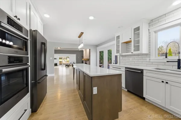 a kitchen with stainless steel appliances granite countertop a refrigerator a stove and a sink