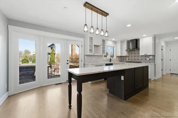 a kitchen with kitchen island granite countertop a sink cabinets and wooden floor