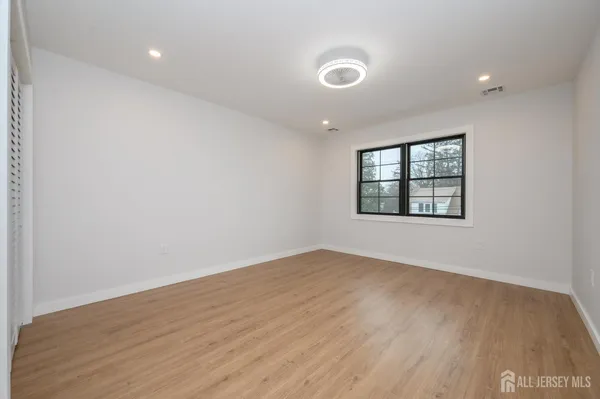 a view of an empty room with wooden floor