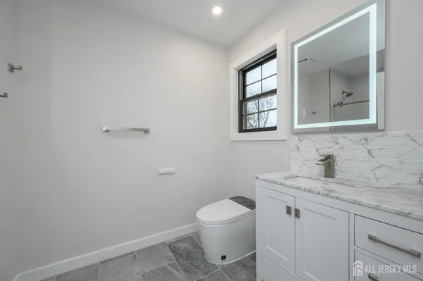 a view of an empty room with wooden floor and closet