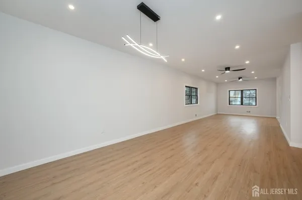 a kitchen with kitchen island a stove a sink a center island and wooden floor