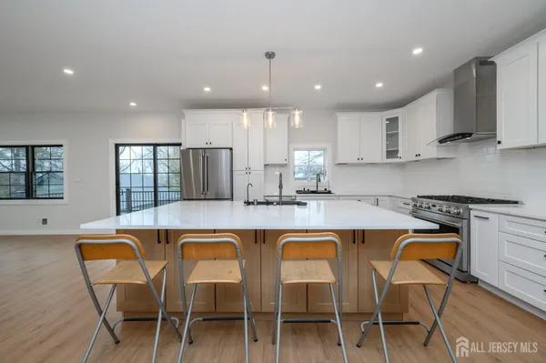 a kitchen with stainless steel appliances granite countertop a stove a sink and a refrigerator