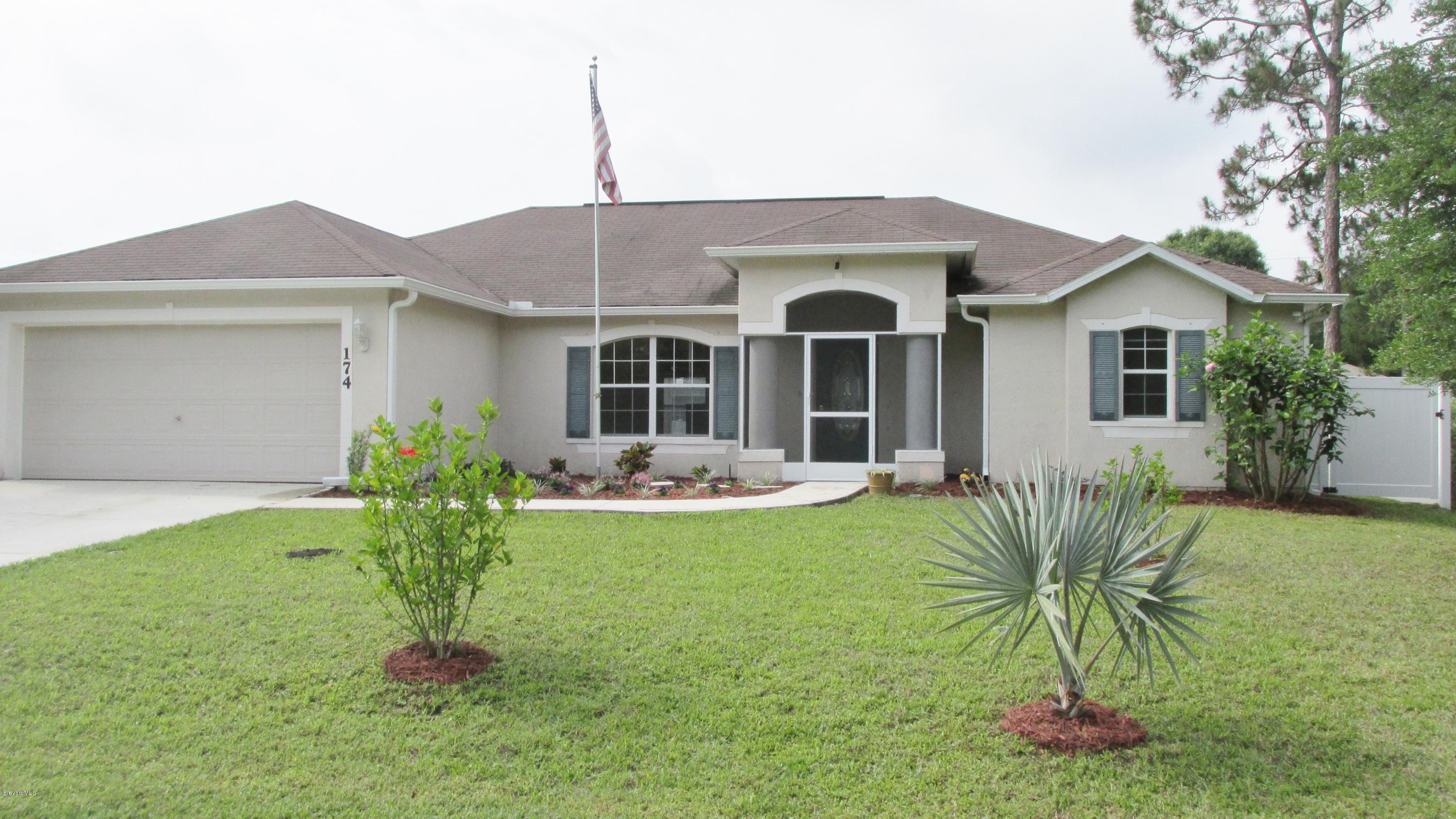 174 Tudor Road Southwest Palm Bay, FL 32908 - Photo 1 of 20 a front view of a house with garden