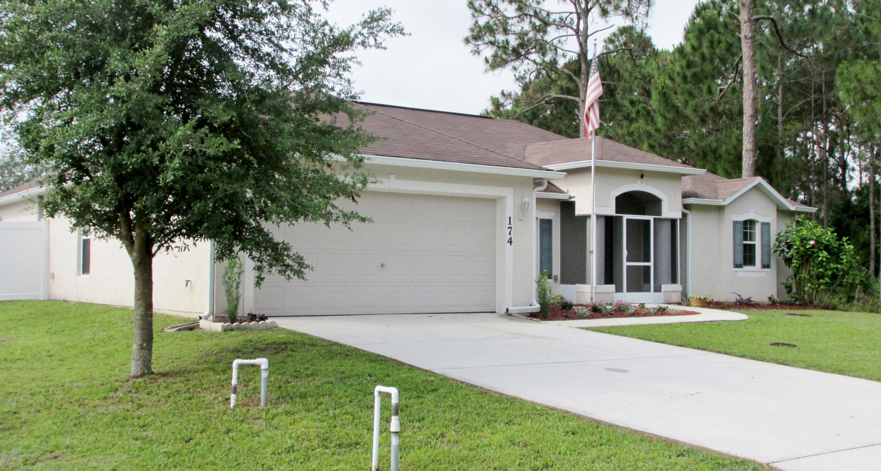 174 Tudor Road Southwest Palm Bay, FL 32908 - Photo 2 of 20 a front view of a house with garden