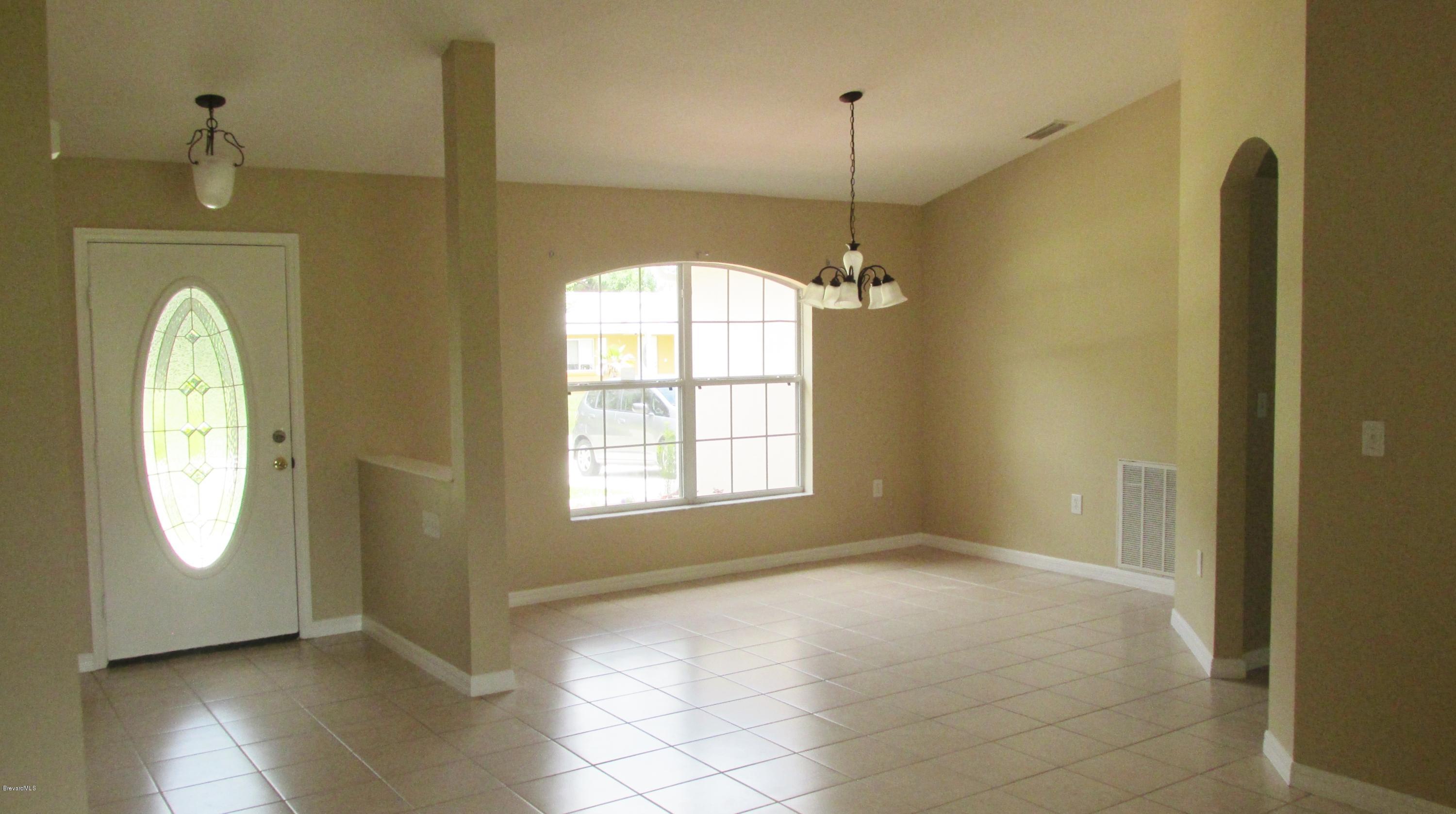 174 Tudor Road Southwest Palm Bay, FL 32908 - Photo 11 of 20 a view of a hallway with windows and chandelier