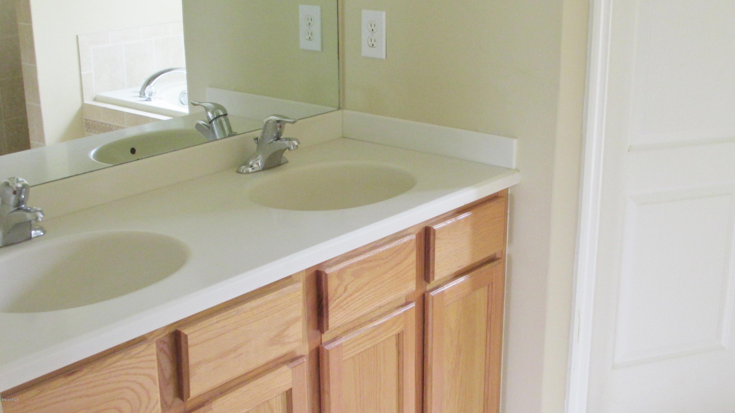 174 Tudor Road Southwest Palm Bay, FL 32908 - Photo 3 of 20 a bathroom with a sink and a large mirror