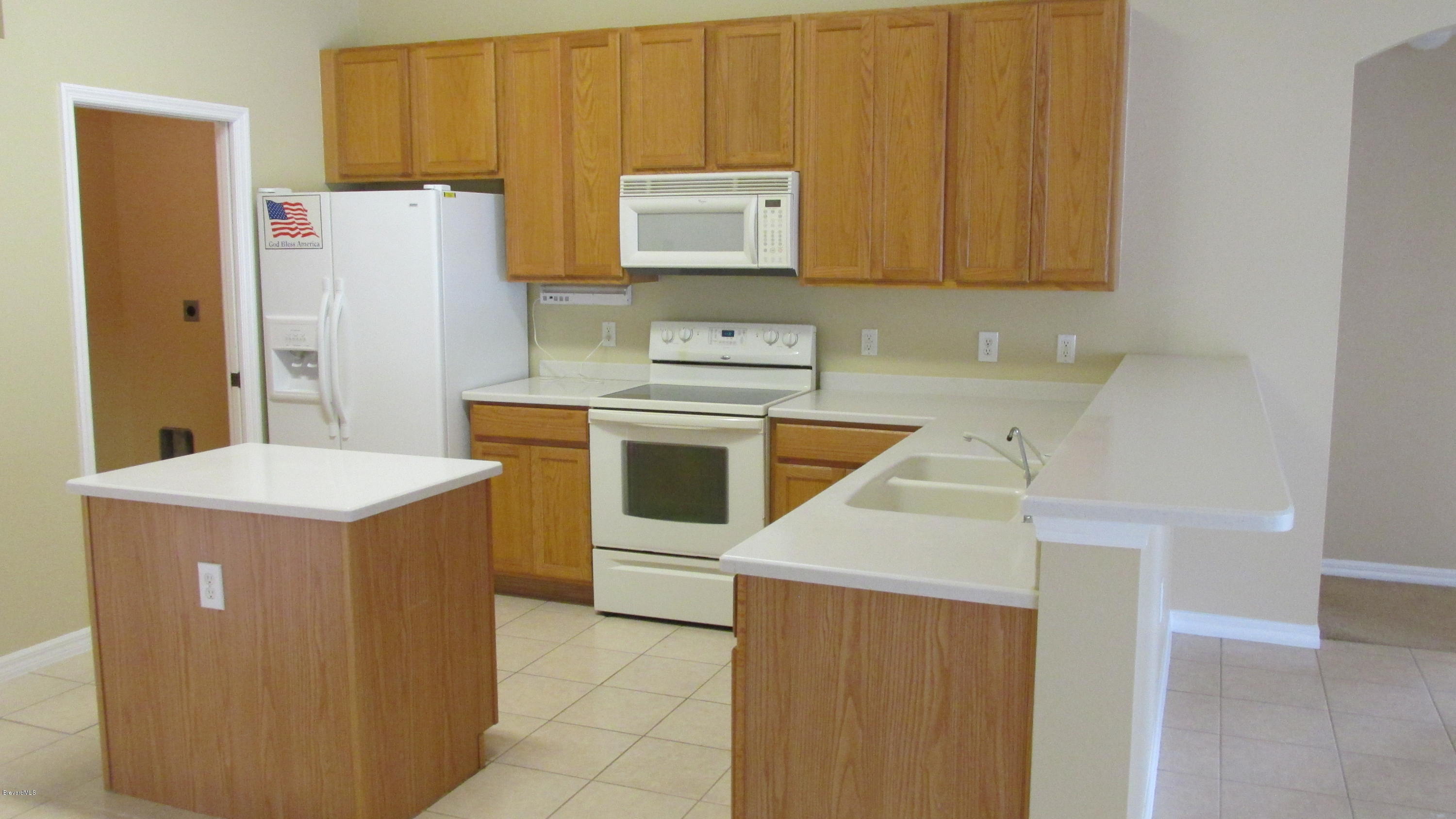 174 Tudor Road Southwest Palm Bay, FL 32908 - Photo 8 of 20 a kitchen with a stove a refrigerator and a sink