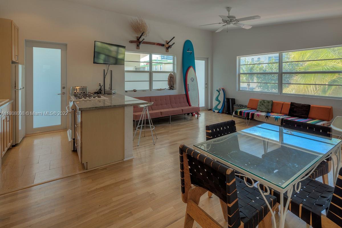 101 Collins Avenue, Unit 26 Miami Beach, FL 33139 - Photo 1 of 7 a kitchen with a table chairs and a wooden floor
