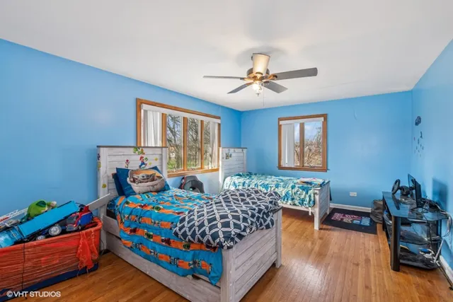 a bedroom with bed and a wooden floor