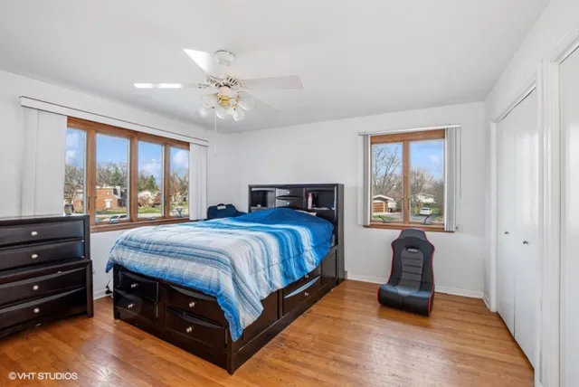 a spacious bedroom with a bed a dresser and large window