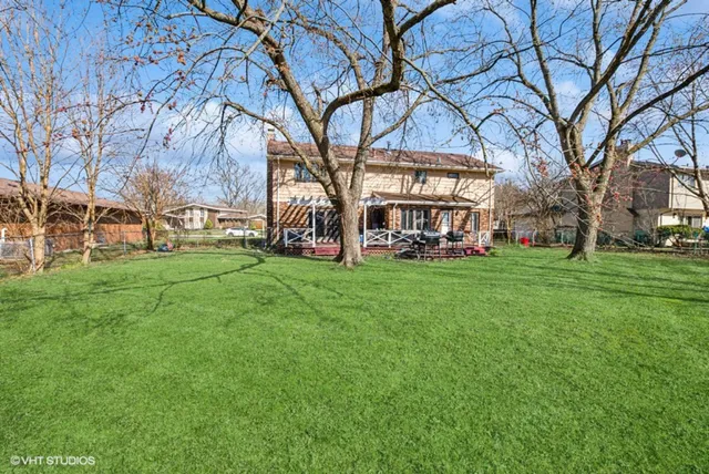 a view of a building with a big yard and large trees