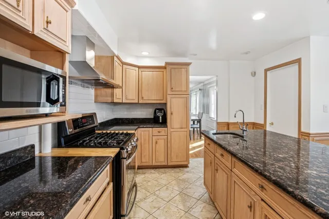 a kitchen with stainless steel appliances granite countertop a sink stove and cabinets